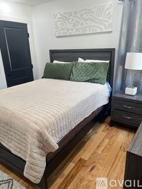 Newark apartment for rent - A bedroom with a large bed and a painting on the wall.