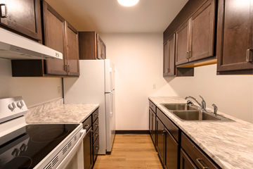 Bismarck apartment for rent - A kitchen with a refrigerator, stove, and sink.