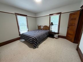 Grinnell apartment for rent - A bedroom with a bed, nightstand, and window.