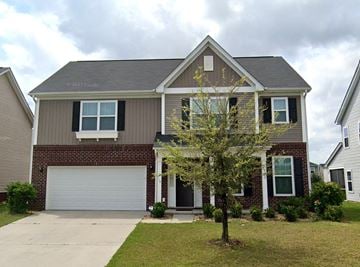 Savannah house for rent - A two-story house with a garage and a tree in front.