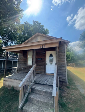 Trumann house for rent - A small wooden building with the number 128 on it.