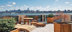 Jersey City apartment for rent - a balcony with a table and chairs and a view of the city
