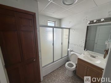 Binghamton apartment for rent - A kitchen with white cabinets and a black fridge.