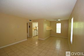 Corpus Christi apartment for rent - A room with beige walls and tiled flooring, with a doorway leading to another room.