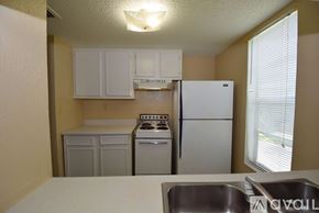 Corpus Christi apartment for rent - A kitchen with a white refrigerator, a white stove, and white cabinets.