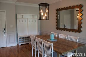 Charleston apartment for rent - A dining room with a wooden table and white chairs.