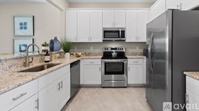 Naples house for rent - A modern kitchen with white cabinets and stainless steel appliances.