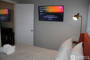 Charleston apartment for rent - A bedroom with a bed, a lamp, and a flat screen TV mounted on the wall.