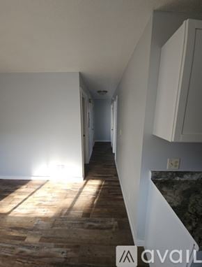La Crosse apartment for rent - A room with wooden flooring and a black refrigerator.