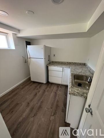 Woodbridge house for rent - A kitchen with a white fridge and a sink with a granite countertop.