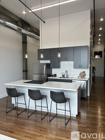 Joplin apartment for rent - A modern kitchen with a white island and black chairs.
