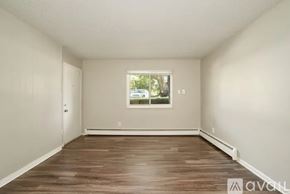 Longmont apartment for rent - A room with wooden flooring and a window showing trees outside.