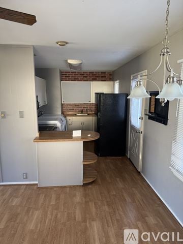 Evansville house for rent - A kitchen with a black refrigerator and wooden floors.