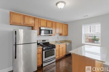 Chicago apartment for rent - A kitchen with wooden cabinets and a stainless steel refrigerator.