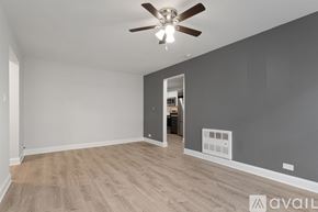 Chicago apartment for rent - A room with a ceiling fan and light, wooden flooring, and a wall-mounted air conditioning unit.
