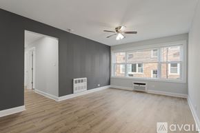 Chicago apartment for rent - A spacious room with a ceiling fan and large windows.