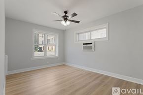 Chicago apartment for rent - A room with a ceiling fan and two windows.