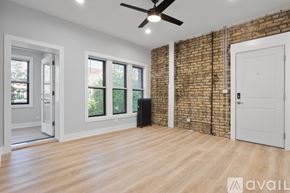 Chicago apartment for rent - A room with a brick wall and wooden flooring.