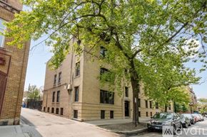 Chicago apartment for rent - A tree with green leaves is in front of a building.