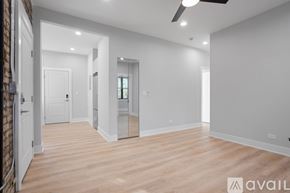 Chicago apartment for rent - A spacious room with wooden flooring and white walls.