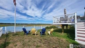 Wells house for rent - A white deck with chairs and an American flag on a sunny day.