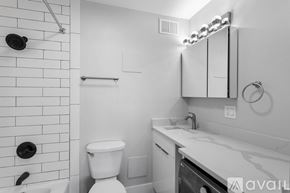 Chicago apartment for rent - A white bathroom with a toilet, sink, and shower.