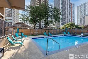 Chicago apartment for rent - A swimming pool surrounded by a fence with a tree in the background.