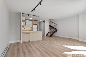 Chicago apartment for rent - A spacious room with wooden flooring and a staircase.