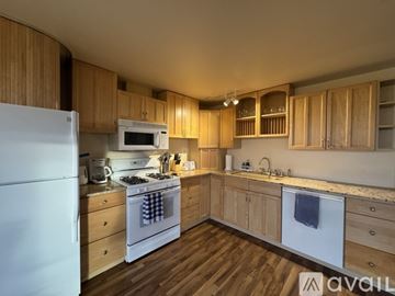 Anchorage apartment for rent - A kitchen with wooden cabinets and a white refrigerator.