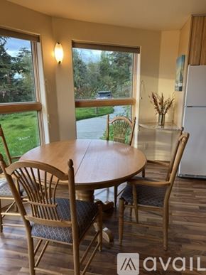 Anchorage apartment for rent - A dining room with a table and chairs and a window overlooking a driveway.