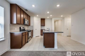 Princeton house for rent - A kitchen with brown cabinets and a black countertop.