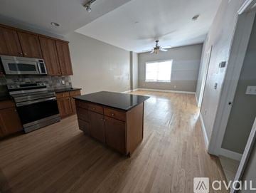 Denver condo for rent - A kitchen with wooden cabinets and a black countertop.