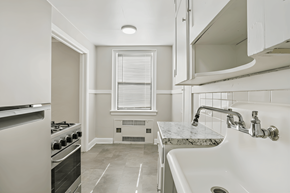 Denver apartment for rent - A white kitchen with a sink and a window.