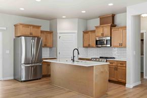 Twin Falls house for rent - A kitchen with wooden cabinets and a white island.