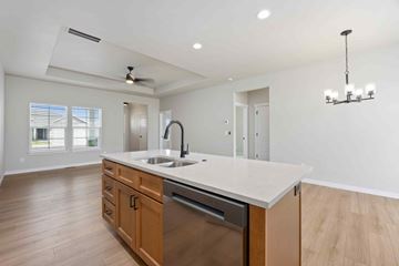 Twin Falls house for rent - A kitchen with a white counter top and wooden cabinets.