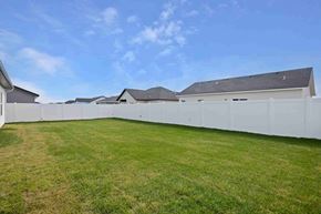 Twin Falls house for rent - A white fence surrounds a grassy area with houses in the background.