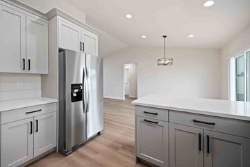 Twin Falls house for rent - A modern kitchen with a stainless steel refrigerator and white cabinets.