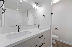 Twin Falls house for rent - A white bathroom with a double sink and a toilet.