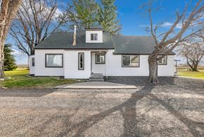 Kimberly house for rent - A white house with a black roof and a gravel driveway.
