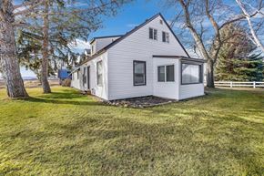 Kimberly house for rent - A house with a grey roof and white walls is surrounded by a grassy area and trees.