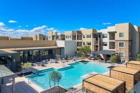 Phoenix apartment for rent - A large swimming pool is surrounded by apartment buildings.