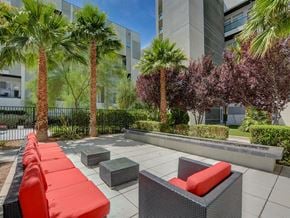 Las Vegas apartment for rent - a seating area with red couches and stools in front of tall buildings
