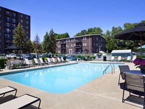 Weymouth apartment for rent - a swimming pool with chairs and umbrellas in front of a building