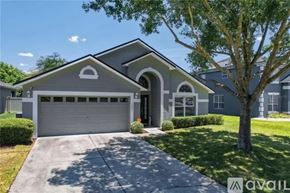 Orlando house for rent - A house with a garage and a tree in front.