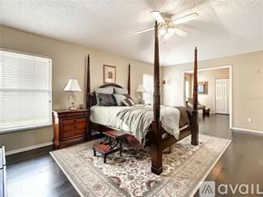 Orlando house for rent - A bedroom with a four poster bed and a rug on the floor.