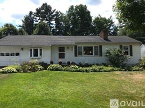 Fayetteville apartment for rent - A white house with a grey roof and a garden in front.