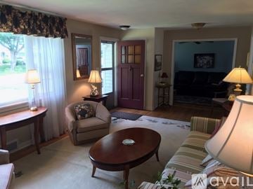 Fayetteville apartment for rent - A living room with a brown table and a striped couch.