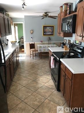 Fayetteville apartment for rent - A kitchen with a tile floor and a ceiling fan.