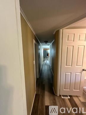 Inverness apartment for rent - A hallway with a white door on the right and a light at the end.