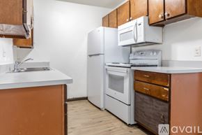 Madison apartment for rent - A kitchen with white appliances and wooden cabinets.